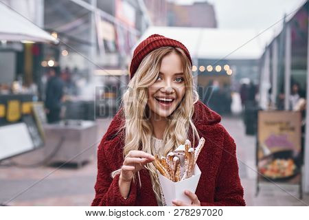 Close-up Of Young Blonde Woman Eatting Churros