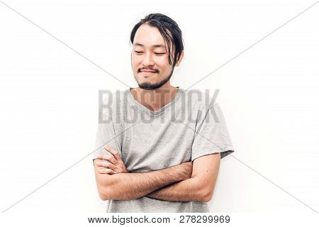 Portrait Of A Asian Young Handsome Man With Arms Crossed And Smiling While Standing Isiolated On Whi