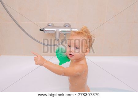 Kid Bath. 1 Year-old Baby Bathes In A Shower. Bath Toy Duck. Happy Little Baby Boy Having Fun To Bat