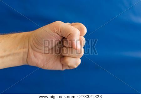 Male Fist On A Blue Background In The Gym. Download Stock Photo.
