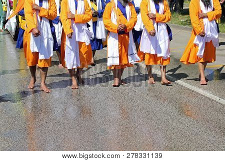 Sikh Soldiers Dressed In Orange Dress Walk Barefoot On The Road During A Religious Rally