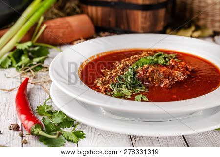 Traditional Georgian And Armenian Cuisine. Tomato Soup With Rice Harcho Of Lamb, With Walnut, Garlic