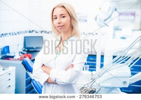 Dental doctor in white uniform in stomathology office