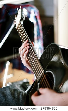 Man Playing Black Guitar On A Sunny Day