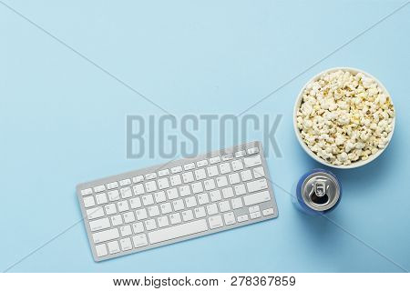 Keyboard And Tin Can With A Drink, Energy Drink, A Bowl Of Popcorn On A Blue Background. The Concept