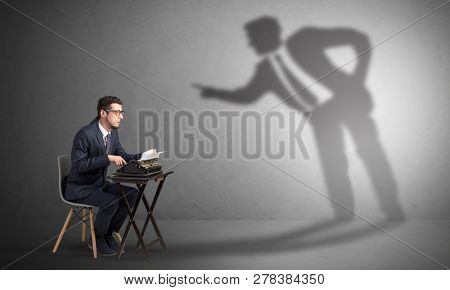 Little man working and a big shadow arguing with him