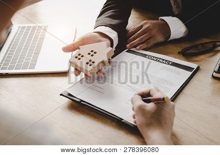 Real Estate Broker Manager Giving Wooden House Model To Customer After Signing Contract For Buying H