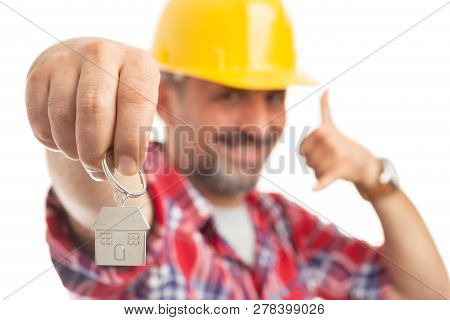 Construction Foreman Presenting House Shaped Silver Key-ring And Making Call Me Gesture With Fingers