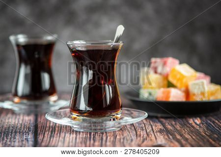 Turkish Glass For Tea Bardak With Turkish Delight On Dark Wooden Table.