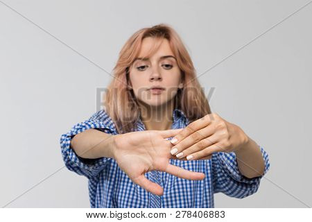 Studio Portrait Of Young Woman Suffering From Pain If Arms, Weakness And Tingling In Hand, Kneads Th
