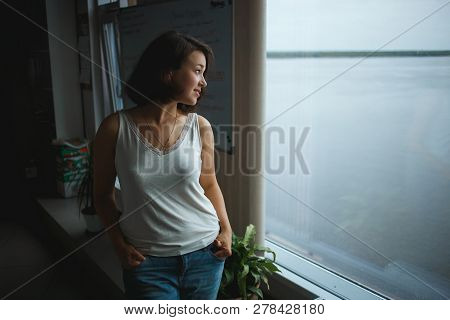 Young Business Woman In Casual Clothes Looking To Window In The Office