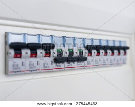Switches In Electrical Fuse Box. Many Black Circuit Breakers In A Row In Position On And Three Switc