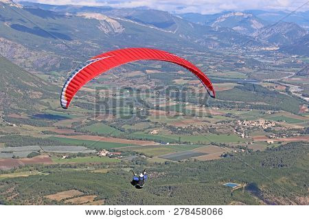 Paraglider Flying His Wing In The French Alps