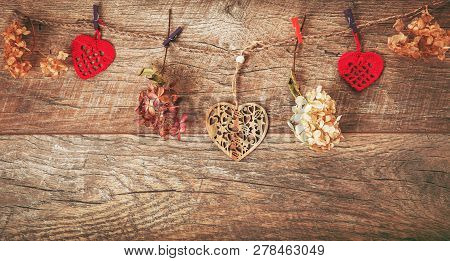 Flowers Composition. Frame Made Of Dried Flowers Hydrangea, Handmade Crocheted Red Hearts On Rustic 