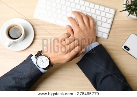 Businessman With Wrist Watch Working At Office Table, Closeup. Time Management
