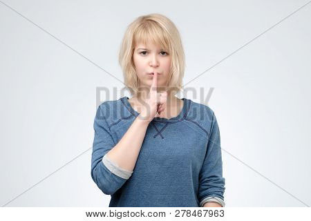 Serious Lovely Female Asks To Keep Secret Information Confidential, Dressed In Blue Pulover