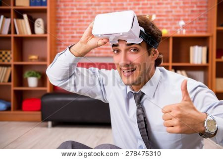 Young employee with virtual glasses during break in the office 