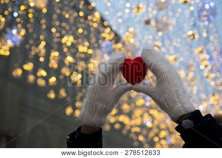 Hands In White Mitterns With Red Heart On The Whinter Background With Lights