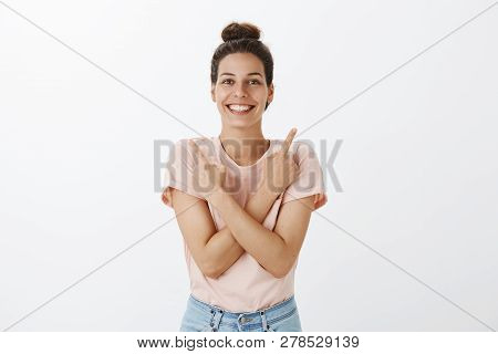 Optimistic Good-looking Friendly And Young Womanw Ith Tan And Bright Smile Pointing Sideways With Ar