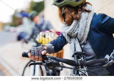 Active Senior Couple With Electrobikes Standing Outdoors On A Road In Town.