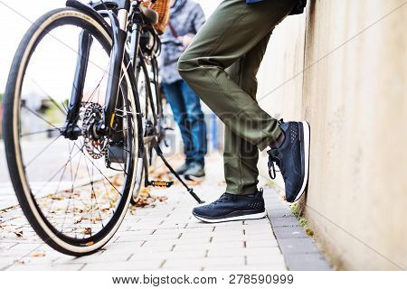 Midsection Of Senior Couple With Electrobikes Standing Outdoors On A Road In Town.
