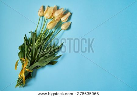 Bouquet Of Yellow Tulips On Blue Pastel Background, Copy Space. Sping Minimal Concept. Womens Day, M