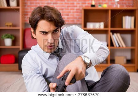 Young employee playing joystick games during his break 