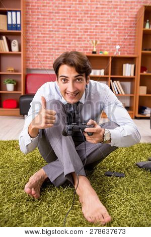 Young employee playing joystick games during his break 