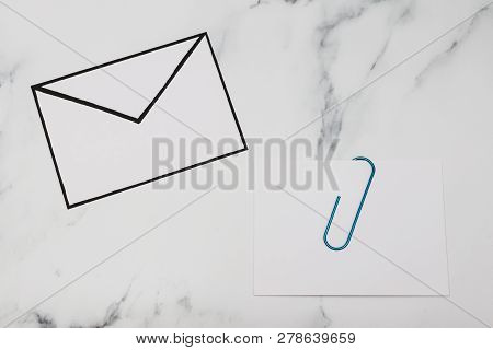 Funny Metaphor Of Inbox With Email Envelop And Attachment Clip On Real-life Desk