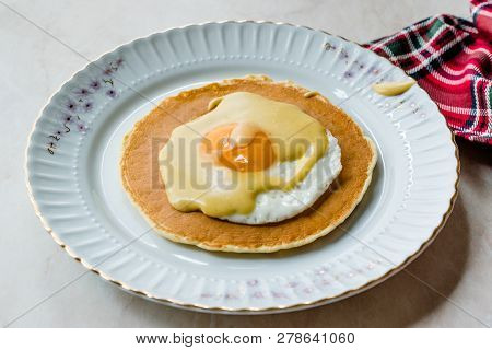 Salted Pancake With Hollandaise Suace, Eggs And Crispy Bacon For Breakfast. Salty Organic Fast Food.