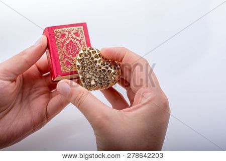 Hand Holding Heart Shape  And Islamic Holy Book Quran