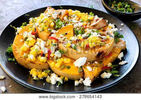 Salad of roasted butternut squash or pumpkin, with sweetcorn and chili salsa, feta cheese and pepitas.  Topped with mint.