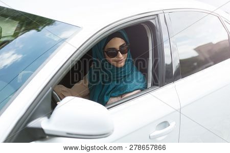 Smiling Arabian Lady In Sunglasses Sitting In Her Car And Lookin Out Open Car Window Car.