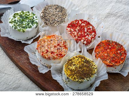 Assortment Of French Fresh White Soft Goat Cheeses With Different Tastes Topping Made With Herbs, Pa