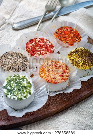 Assortment Of French Fresh White Soft Goat Cheeses With Different Tastes Topping Made With Herbs, Pa