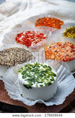 Assortment Of French Fresh White Soft Goat Cheeses With Different Tastes Topping Made With Herbs, Pa