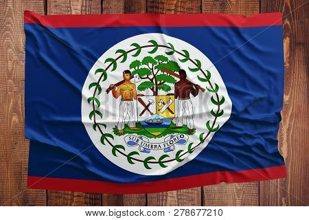 Flag Of Belize On A Wooden Table Background. Wrinkled Belizean Flag Top View.