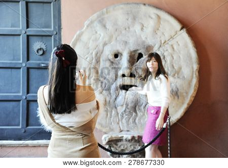Rome, Italy - October 10, 2018: Beautiful Asian Women Photograph Each Other In Front Of The Mouth Of
