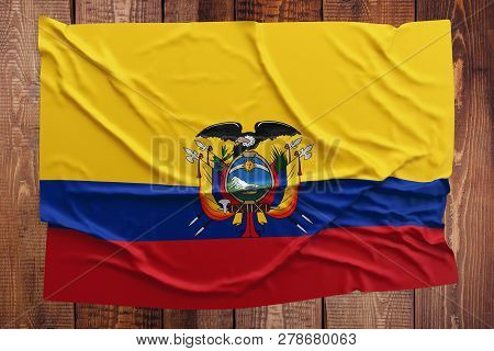 Flag Of Ecuador On A Wooden Table Background. Wrinkled Ecuadorean Flag Top View.