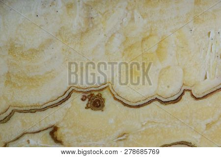 Background From A Light Yellow Natural Stone Onyx With Bubbles And Stains On The Surface Is Called O