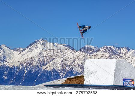 Sochi, Russia - March 25, 2014: Man Snowboarder Flies Freestyle In The Air From The Jump On Chugush 