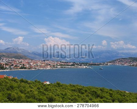 View Of Vivid Landscape With Royal Blue Sea, Bright Green Foliage, Mountains And An Old City With Re