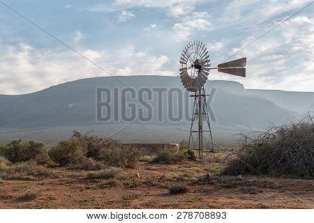 An Early Morning Landscape, With A Windmill And Dam, In The Tankwa Karoo Of South Africa