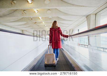 Young Woman In International Airport With Luggage On Travelator