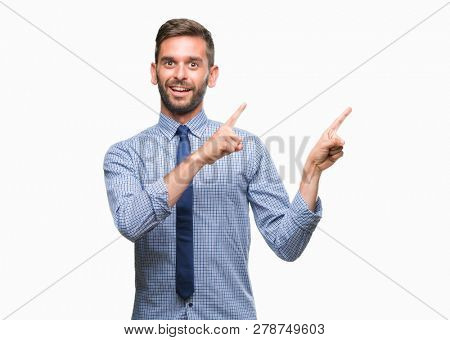 Young handsome business man over isolated background smiling and looking at the camera pointing with two hands and fingers to the side.