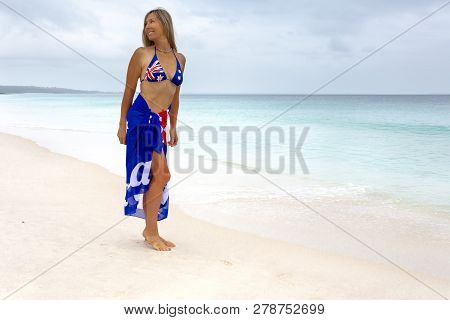 Aussie Beach Woman Barefoot, Smiling, Looking Over Her Shoulder.   She Has A Flag Draped Around Her 