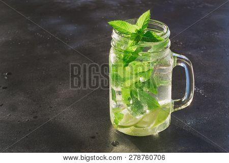 One Mojito Cocktail In Mason Jar On Black Stone Table. Copy Space For Text.