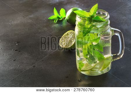 One Mojito Cocktail In Mason Jar On Black Stone Table. Copy Space For Text.