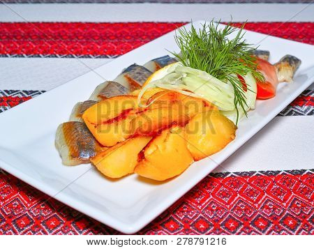 Baked Potato With Pickled Herring Fish Fillet Slices, Served With Onion, Tomato And Parsley On A Whi