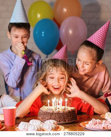 Happy Girl Making Wish, Looking At Birthday Cake, Having Party With Friends